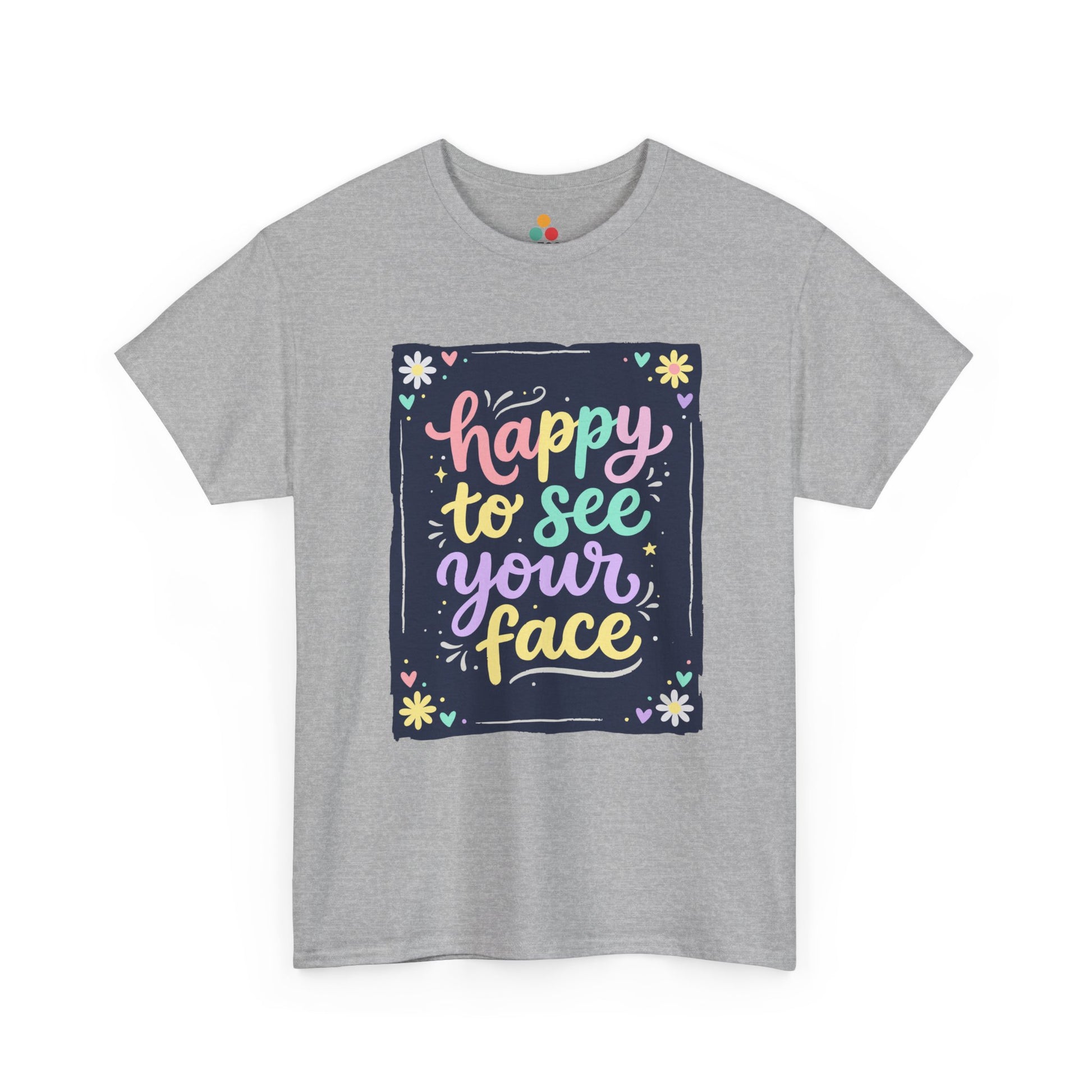 Close-up of a Gray Heather T-shirt featuring a colorful "Happy to See Your Face" hand-lettered graphic framed with flowers and hearts on a navy background panel.
