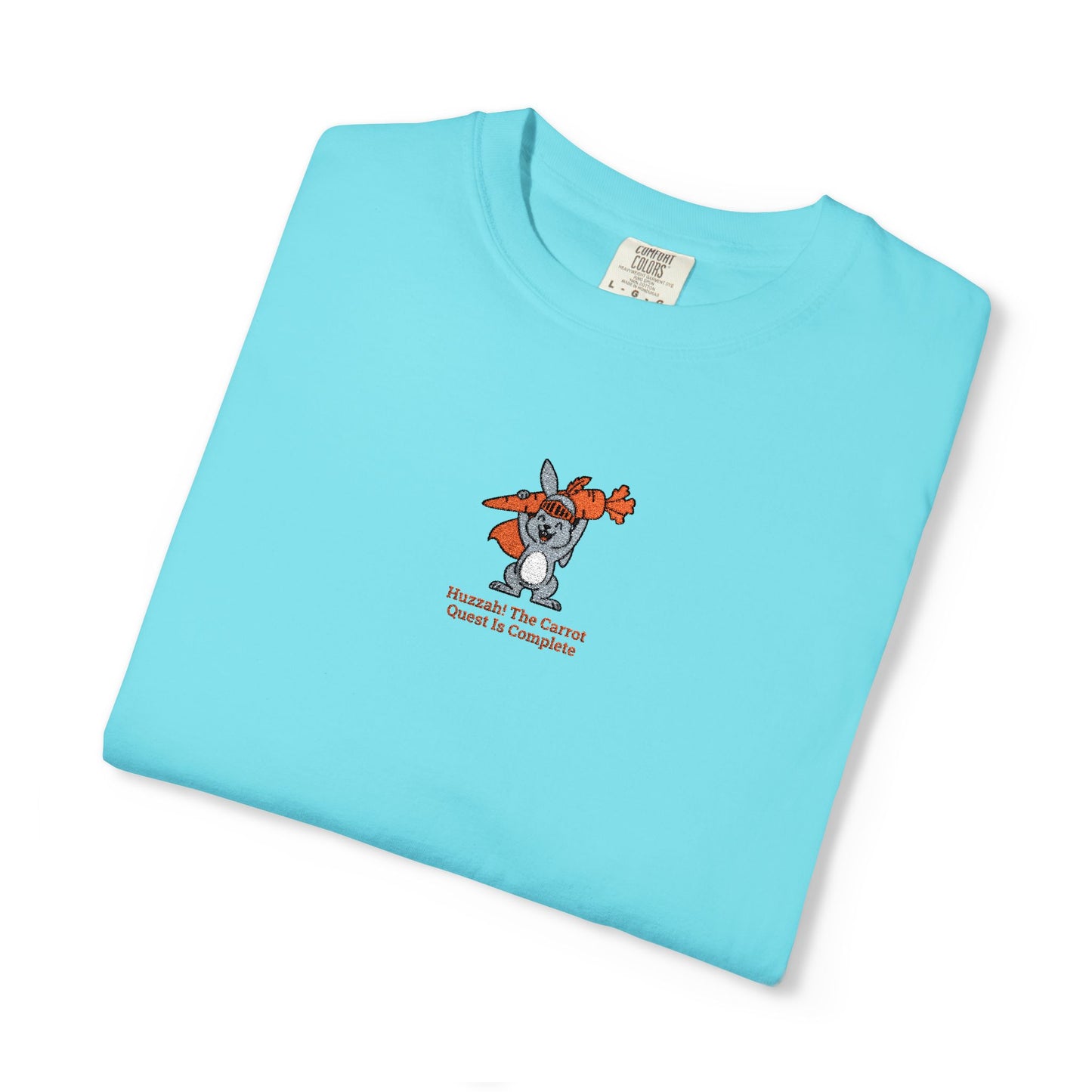  Close-up of a Lagoon Blue  Comfort Colors® Blue Jean shirt featuring a rabbit holding carrots with the saying “Huzzah! The Carrot Quest Is Complete.”

