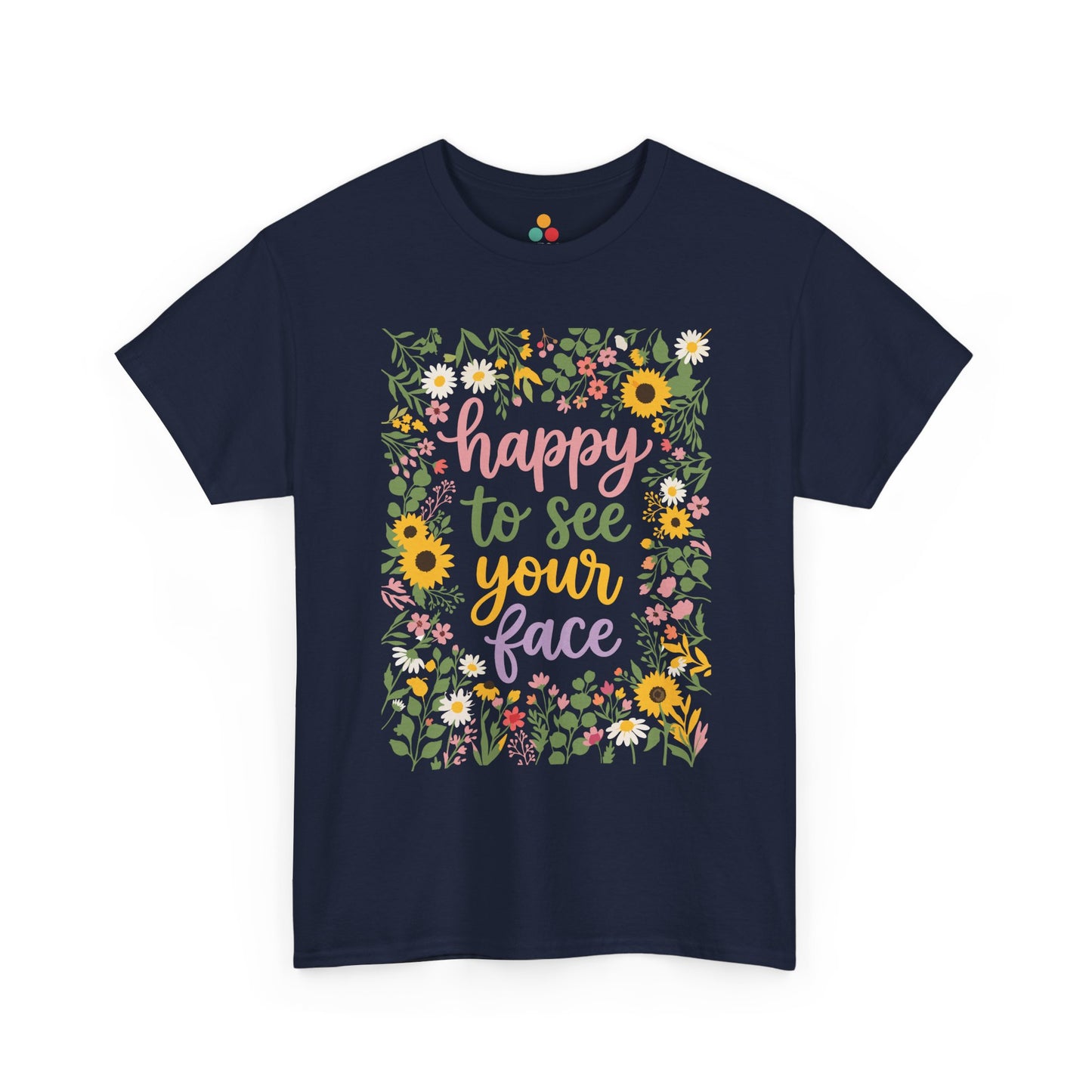 Close-up of a Navy Blue T-shirt featuring the phrase “Happy to See Your Face” in pastel lettering framed by a floral border with sunflowers and wildflowers.

