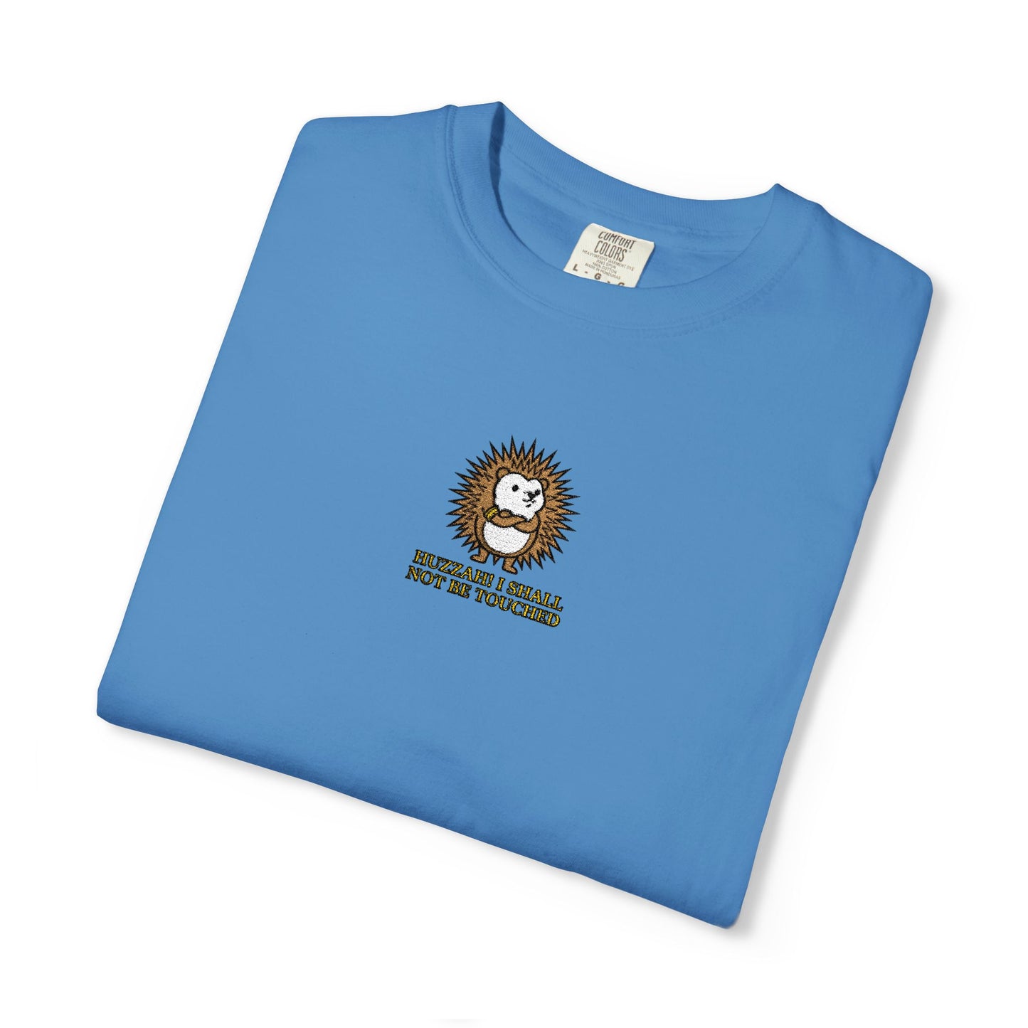Close-up of a Royal Caribe Comfort Colors® shirt featuring an embroidered defensive hedgehog with the saying "Huzzah! I Shall Not Be Touched."

