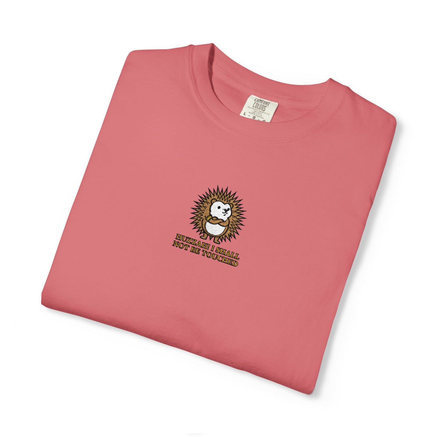 Close-up of a Watermelon Comfort Colors® shirt featuring an embroidered hedgehog with the funny saying "Huzzah! I Shall Not Be Touched."

