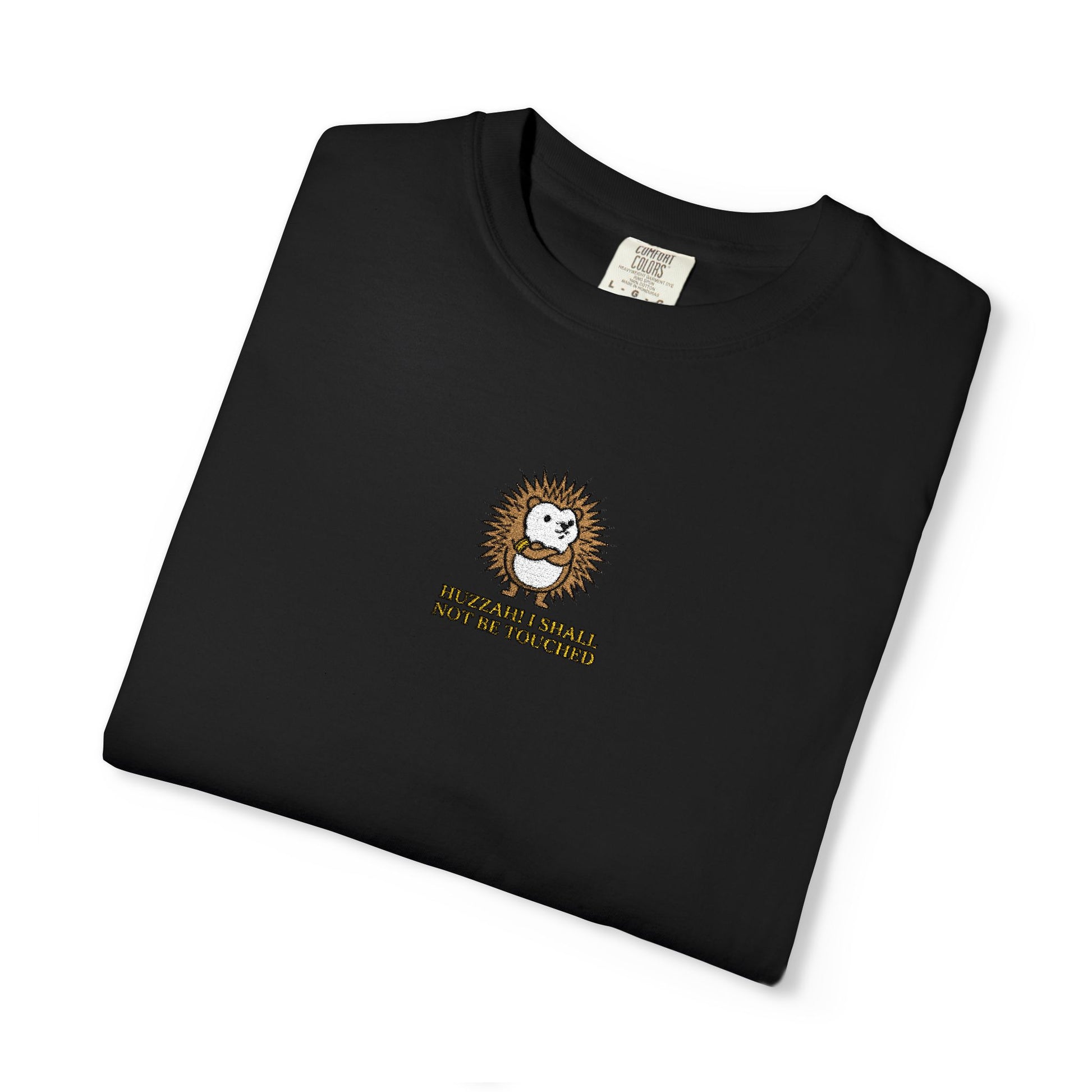 Close-up of a black Comfort Colors® shirt featuring an embroidered spiky hedgehog with the saying "Huzzah! I Shall Not Be Touched."

