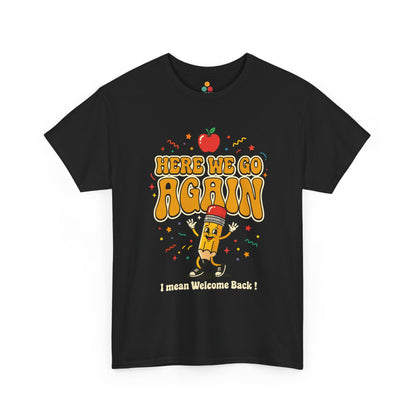 Close-up of a black T-shirt featuring a funny back to school design with the words “Here We Go Again” and “I mean Welcome Back!” plus a red apple and a pencil character.
