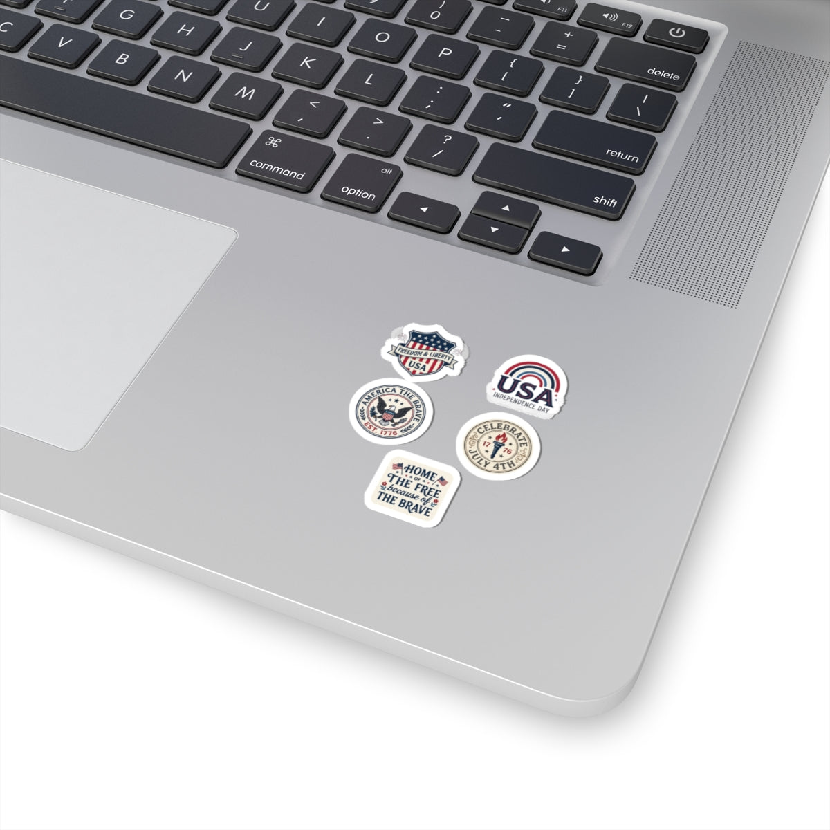 Close-up of a laptop trackpad area decorated with a set of mini TEEZOCA patriotic flag decals.