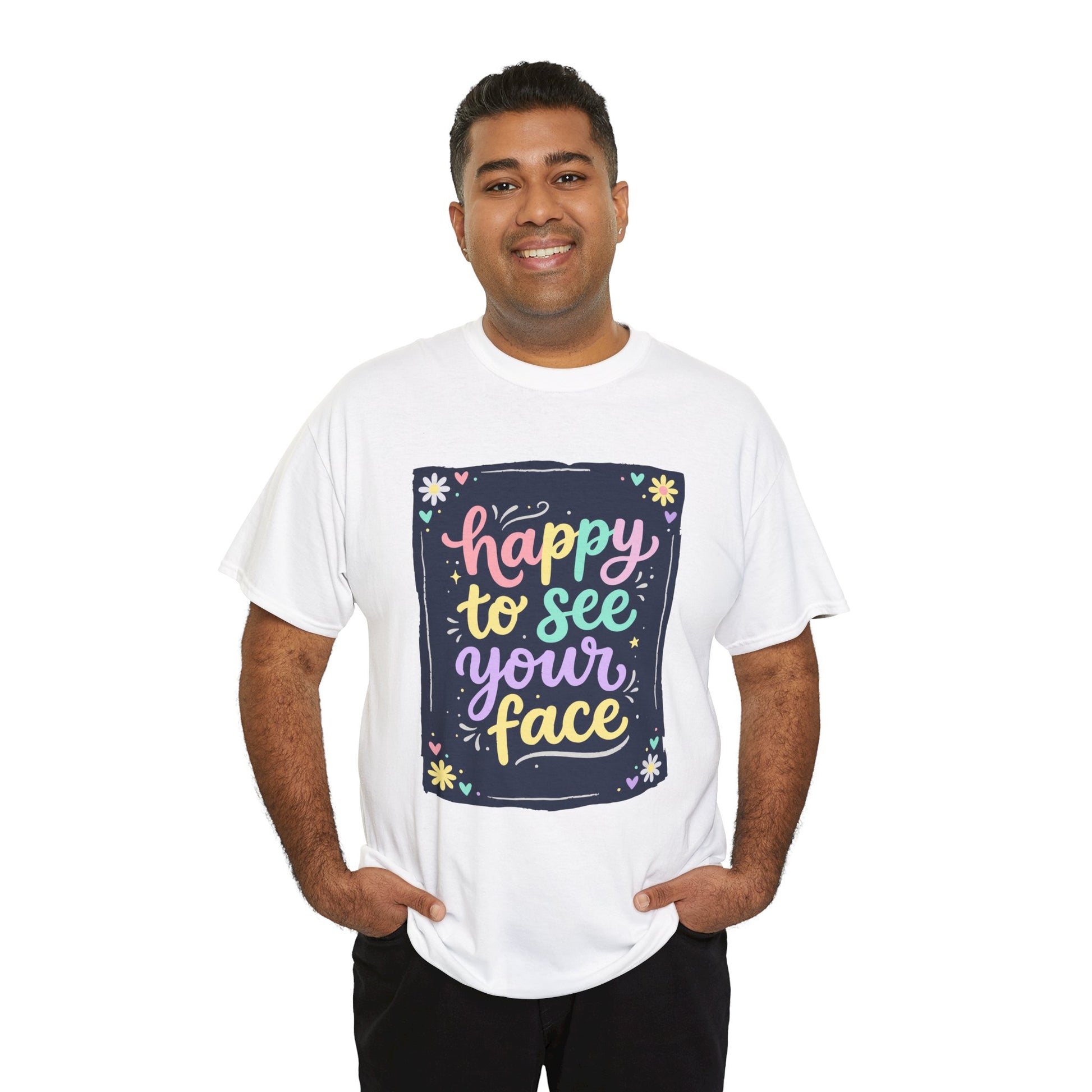 Close-up of a men wearing white T-shirt featuring a colorful "Happy to See Your Face" hand-lettered graphic framed with flowers and hearts on a navy background panel.
