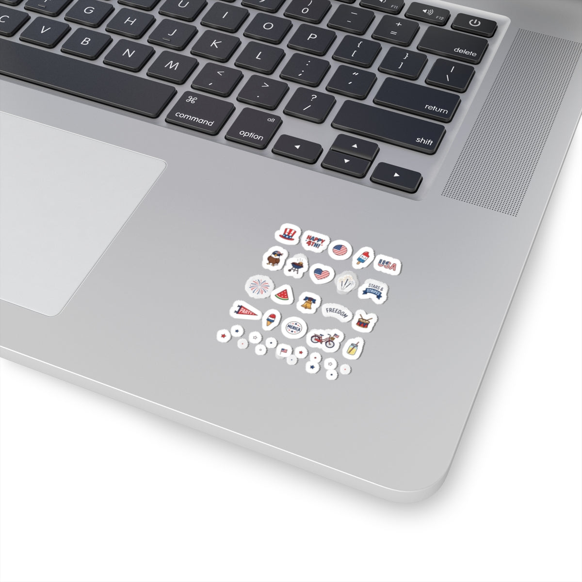 Close-up of a silver laptop corner decorated with an entire collection of mini TEEZOCA holiday doodle decals.