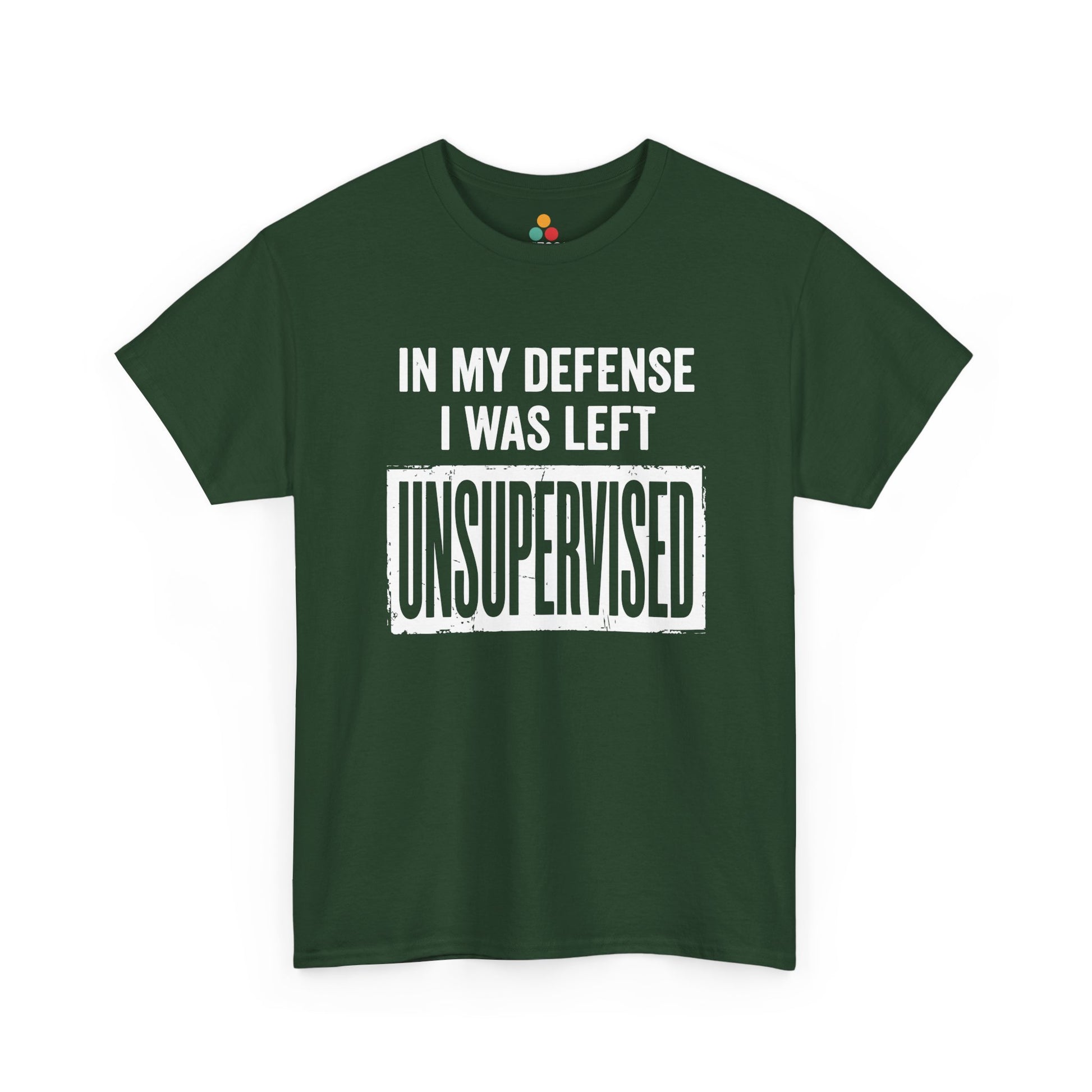 Forest green T-shirt featuring bold white block typography reading "In My Defense I Was Left Unsupervised" with a highlighted "UNSUPERVISED" text box, funny sarcastic quote shirt, witty statement tee, dry humor graphic tee, and bold novelty quote apparel.