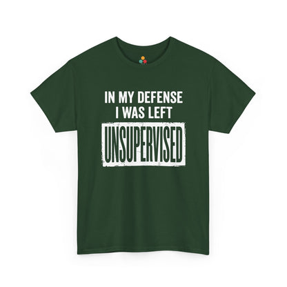 Forest green T-shirt featuring bold white block typography reading "In My Defense I Was Left Unsupervised" with a highlighted "UNSUPERVISED" text box, funny sarcastic quote shirt, witty statement tee, dry humor graphic tee, and bold novelty quote apparel.