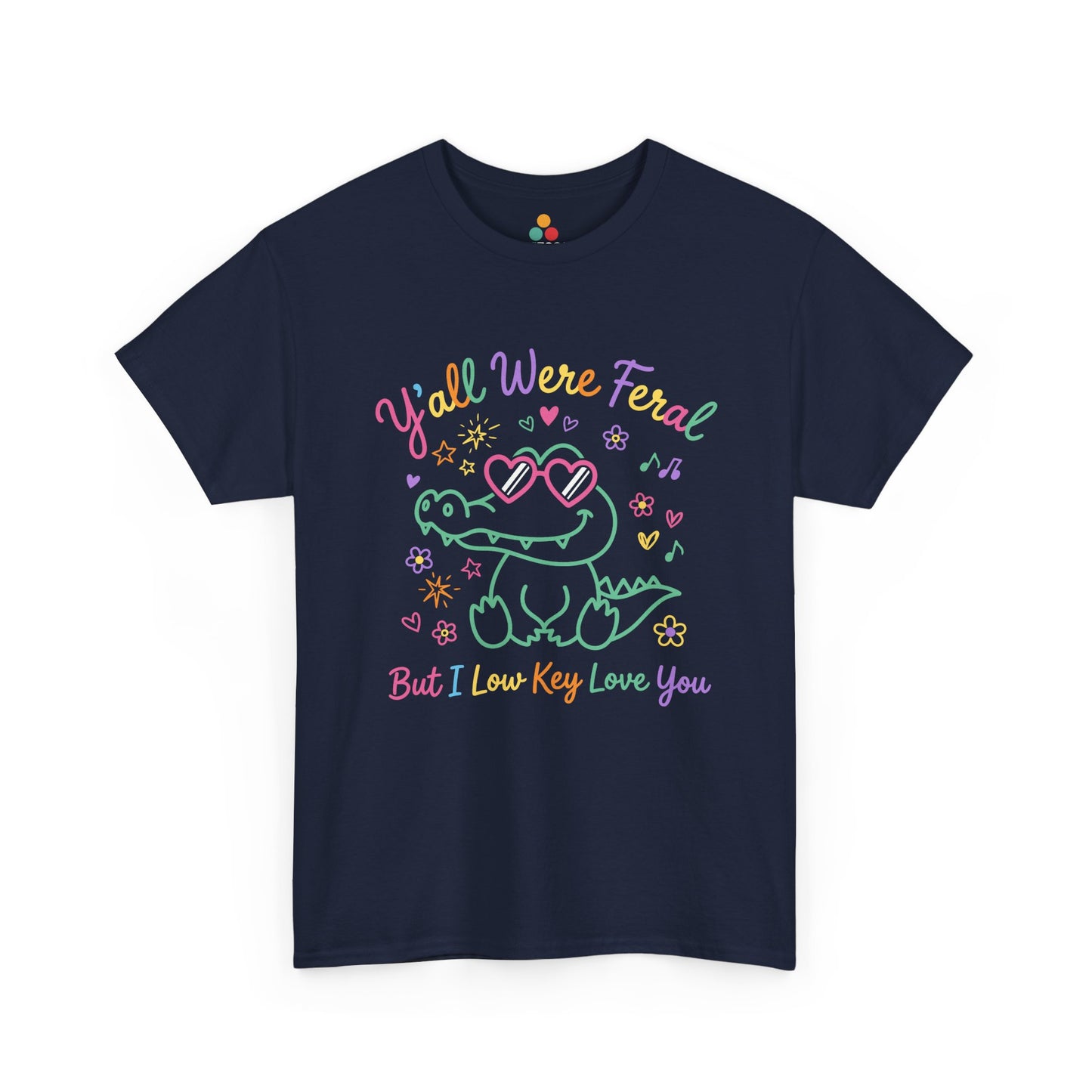 Front view of TEEZOCA navy T-shirt featuring a cute neon crocodile wearing heart-shaped sunglasses surrounded by colorful stars and flowers, with rainbow text reading "Y'all Were Feral But I Low Key Love You" — a funny last day of school teacher gift shirt.

