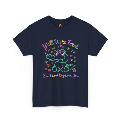 Front view of TEEZOCA navy T-shirt featuring a cute neon crocodile wearing heart-shaped sunglasses surrounded by colorful stars and flowers, with rainbow text reading "Y'all Were Feral But I Low Key Love You" — a funny last day of school teacher gift shirt.

