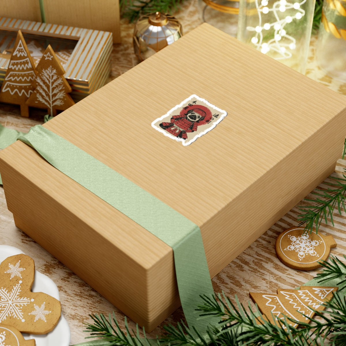 Gift box with decorative ribbon and sticker on a festive background with cookies and lights