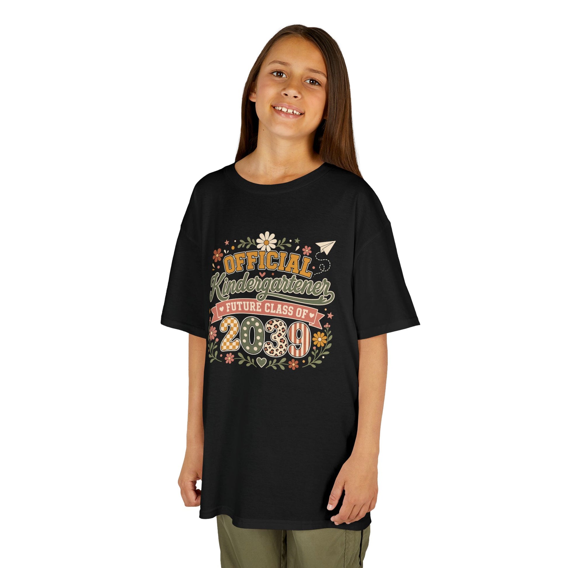 Girl wearing a black TEEZOCA boho Official Kindergartener Future Class of 2039 kids tee, a cute first-day-of-school keepsake shirt.
