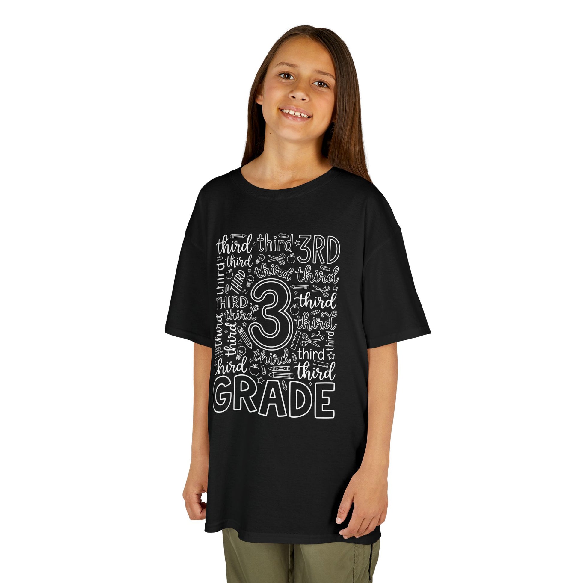Girl wearing a black TEEZOCA third grade typography kids tee reading third grade, a cute first-day-of-school shirt.

