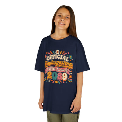 Girl wearing a navy TEEZOCA retro Official Kindergartener Future Class of 2039 kids tee, a cute first-day-of-school keepsake shirt.
