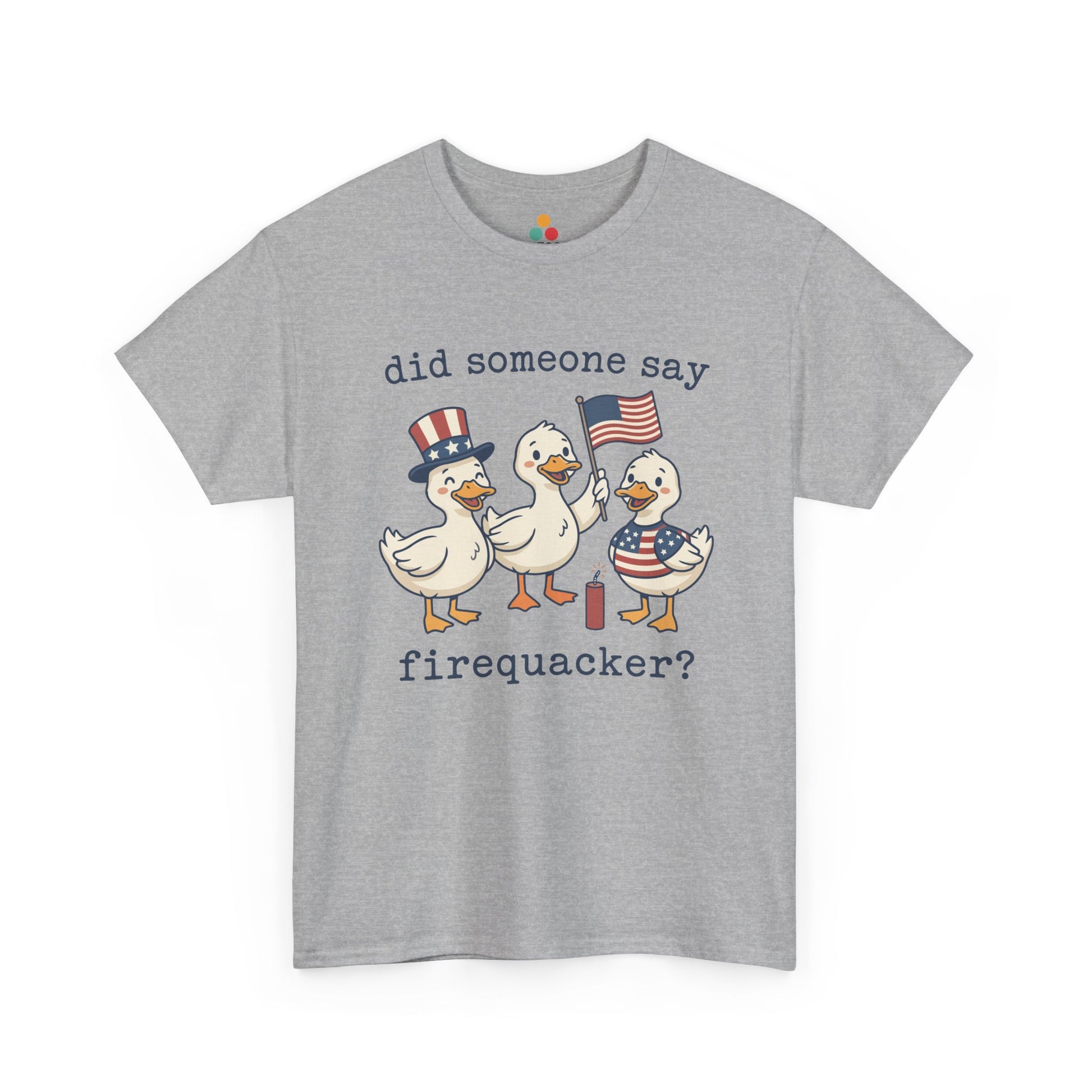 Gray TEEZOCA T-shirt featuring three cartoon patriotic ducks — one in an Uncle Sam hat, one holding a US flag, and one in a stars-and-stripes outfit — around a firecracker with the text "did someone say firequacker?" printed above and below.


