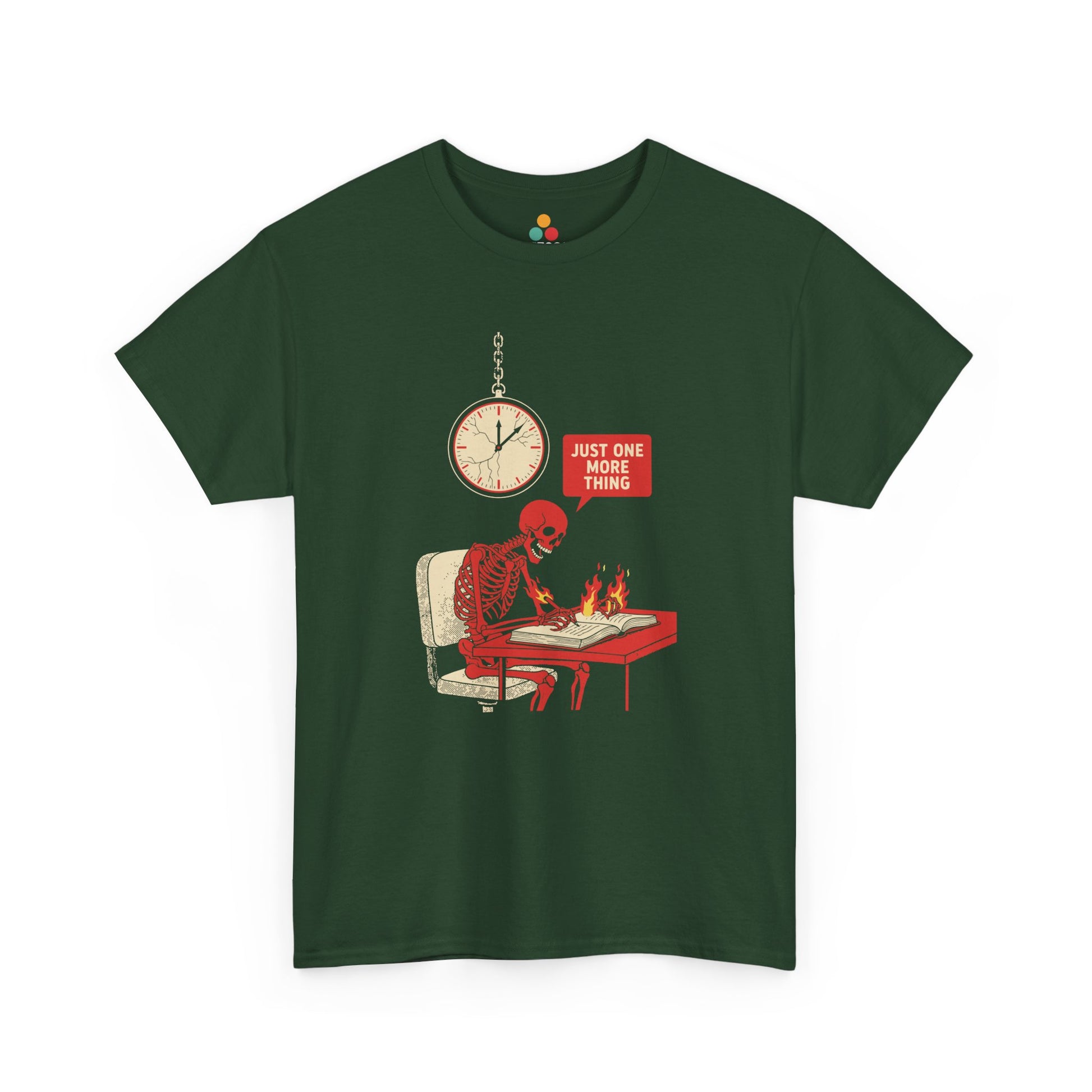 Green t‑shirt featuring a red skeleton sitting at a desk with hands on fire, writing in a book under a wall clock, with a speech bubble saying “Just One More Thing.”
