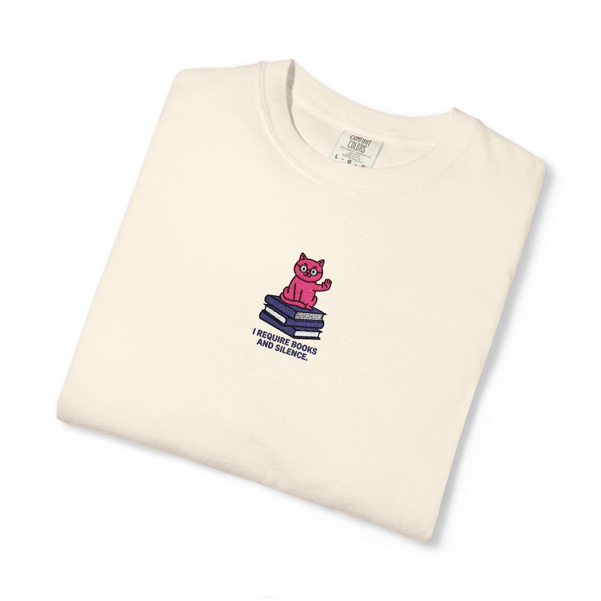 Ivory Comfort Colors®  Island reef  shirt featuring an embroidered pink cat sitting on books with the saying “I Require Books and Silence.”
