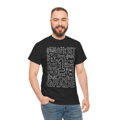 Male first grade teacher wearing a black TEEZOCA first grade typography tee, a unisex back to school shirt for classroom staff.
