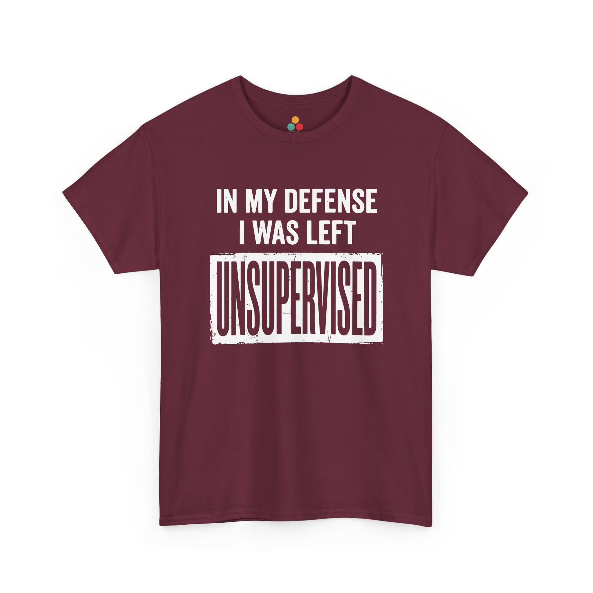 Maroon T-shirt featuring bold white block typography reading "In My Defense I Was Left Unsupervised" with a highlighted "UNSUPERVISED" text box, funny sarcastic quote shirt, witty statement tee, dry humor graphic tee, and bold novelty quote apparel.