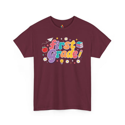 Maroon t-shirt with 'first grade!' text and educational graphics on a white background. TEEZOCA t-shirt pairs bold “First Grade” text with an apple, books, a pencil, and a light bulb for matching first grade teacher squad shirts.