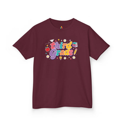 Maroon t-shirt with 'third Grade!' text and graphics on a white background. TEEZOCA t-shirt designed as a cheerful back to school shirt kids can wear for third-grade photos and classroom drop-off.