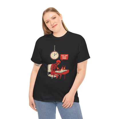 Overworked Skeleton T‑Shirt – “Just One More Thing” Burning Desk Overtime Graphic Tee | TEEZOCA Model Black  t‑shirt featuring a red skeleton sitting at a desk with hands on fire, writing in a book under a wall clock, with a speech bubble saying “Just One More Thing.”
