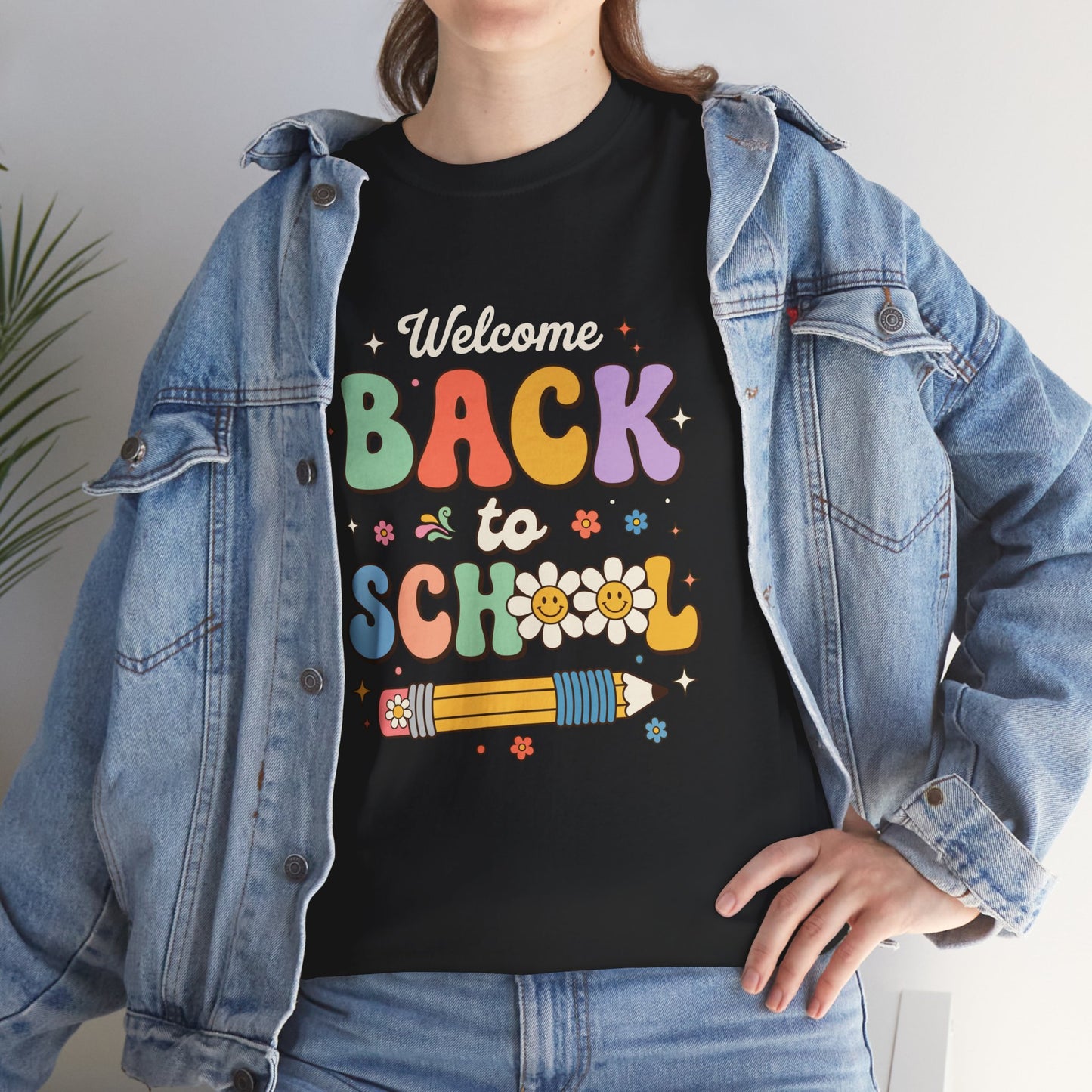Person wearing a black t-shirt with 'Welcome Back to School' text and colorful graphics, paired with a denim jacket.