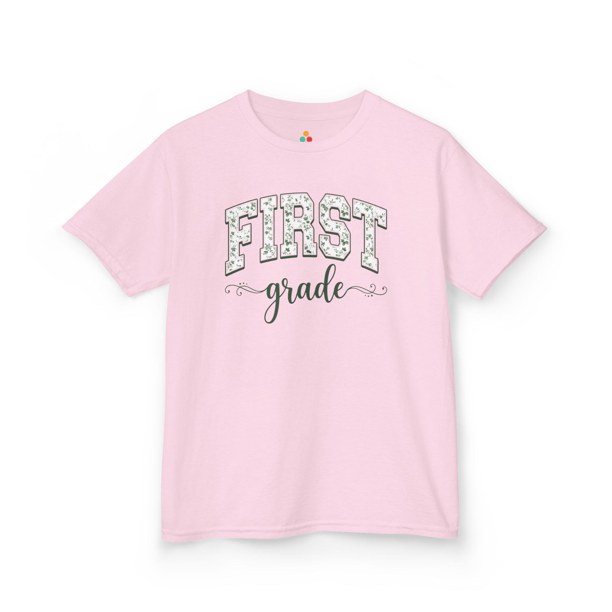 Pink t-shirt with 'FIRST grade' text on a white background. Purple t-shirt. TEEZOCA floral back to school tee for kids in first grade, a first-day pick parents find on Amazon and Etsy for class photos.