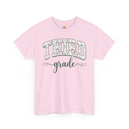 Pink t-shirt with 'THIRD grade' text on a white background. TEEZOCA third grade teacher shirt featuring sage floral varsity lettering, a cute back to school tee for teachers.
