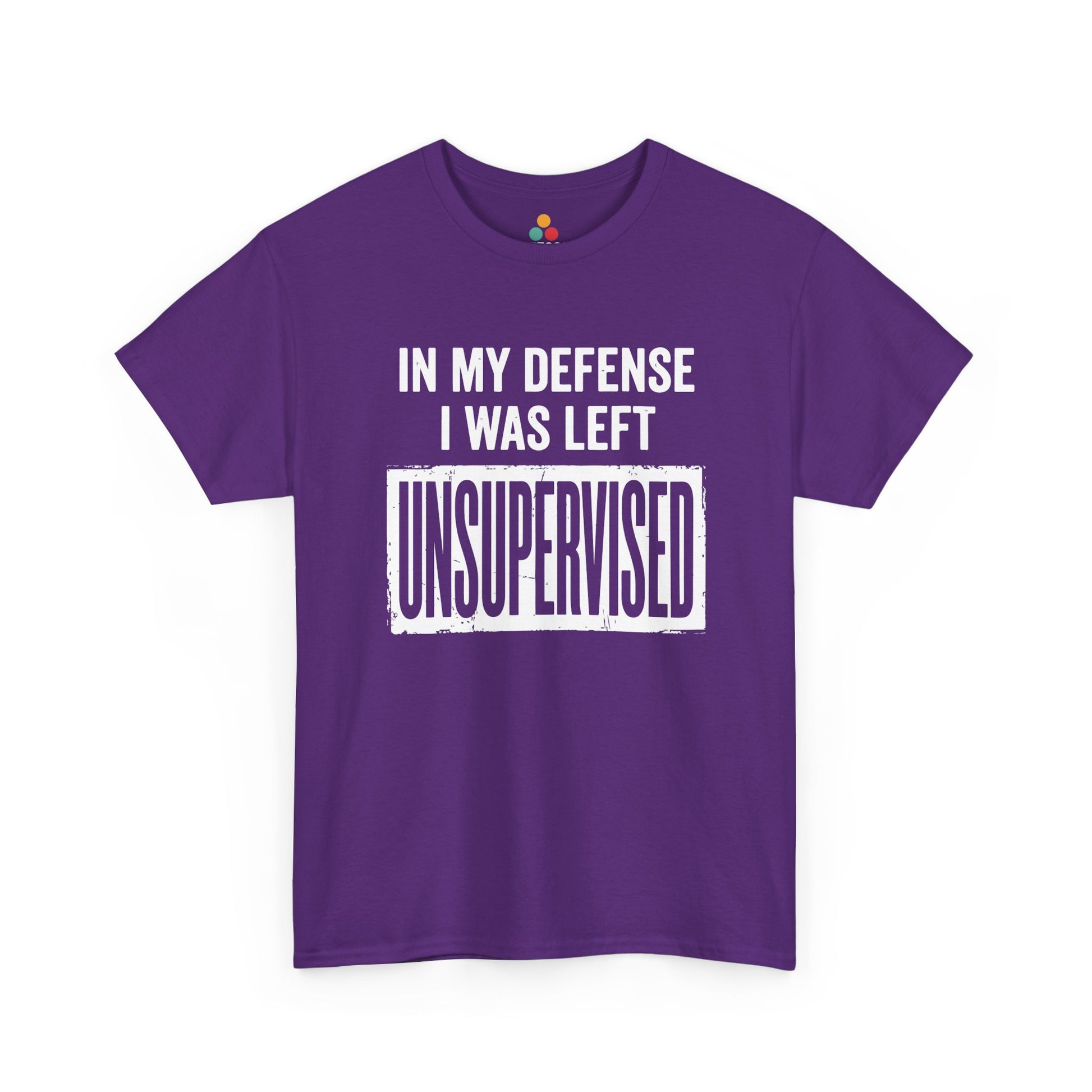 Purple T-shirt featuring bold white block typography reading "In My Defense I Was Left Unsupervised" with a highlighted "UNSUPERVISED" text box, funny sarcastic quote shirt, witty statement tee, dry humor graphic tee, and bold novelty quote apparel.