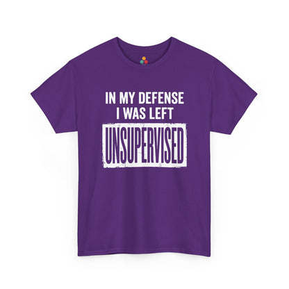 Purple T-shirt featuring bold white block typography reading "In My Defense I Was Left Unsupervised" with a highlighted "UNSUPERVISED" text box, funny sarcastic quote shirt, witty statement tee, dry humor graphic tee, and bold novelty quote apparel.