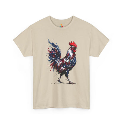 Sand TEEZOCA T-Shirt featuring a bold watercolor-style rooster painted in red, white, and blue American flag colors with stars and paint splashes on white fabric.