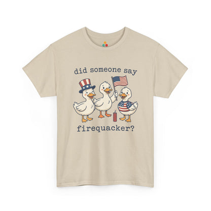 beige  TEEZOCA T-shirt featuring three cartoon patriotic ducks — one in an Uncle Sam hat, one holding a US flag, and one in a stars-and-stripes outfit — around a firecracker with the text "did someone say firequacker?" printed above and below.

