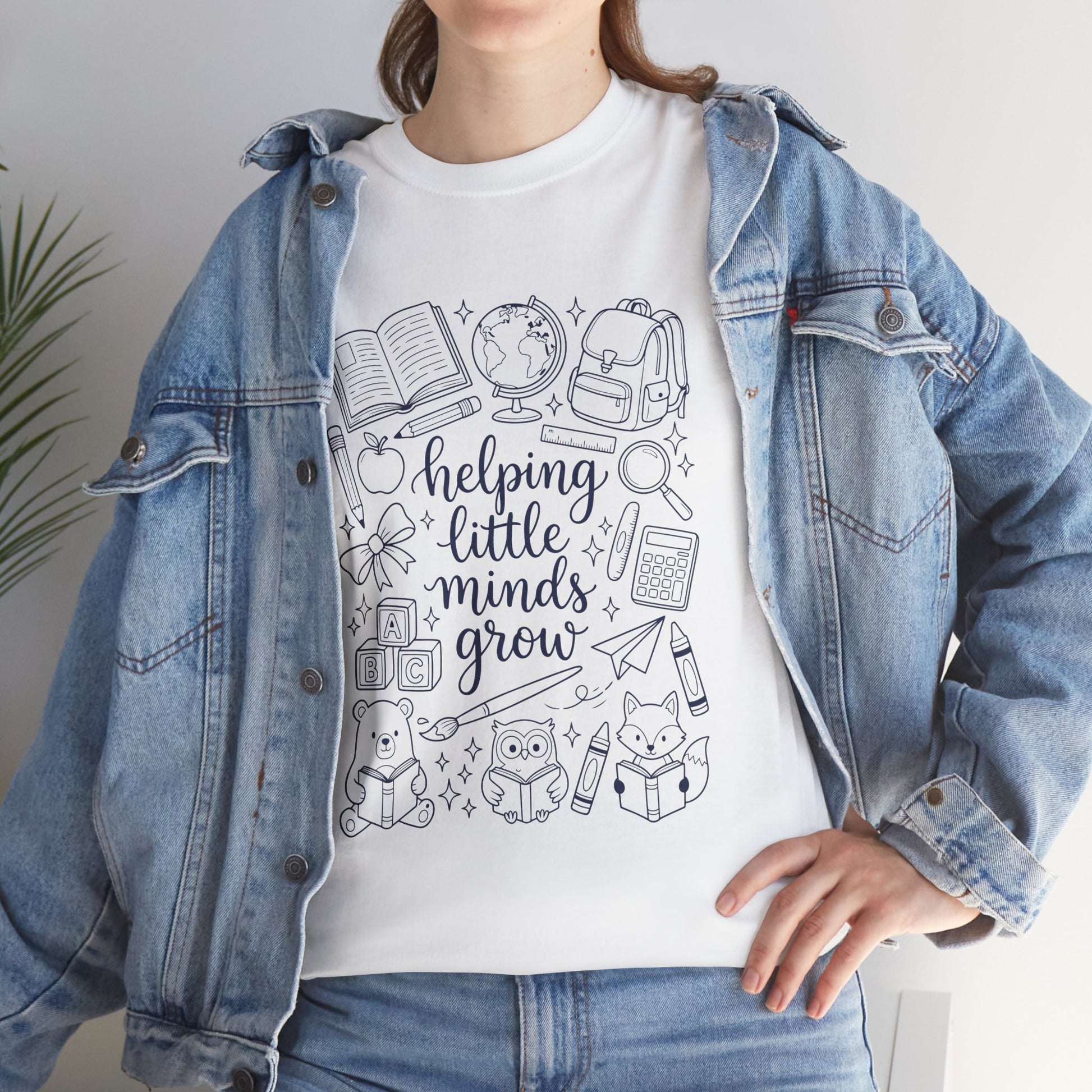 Close up view of TEEZOCA T-Shirt with black and white “helping little minds grow” back to school teacher design on white  fabric.

