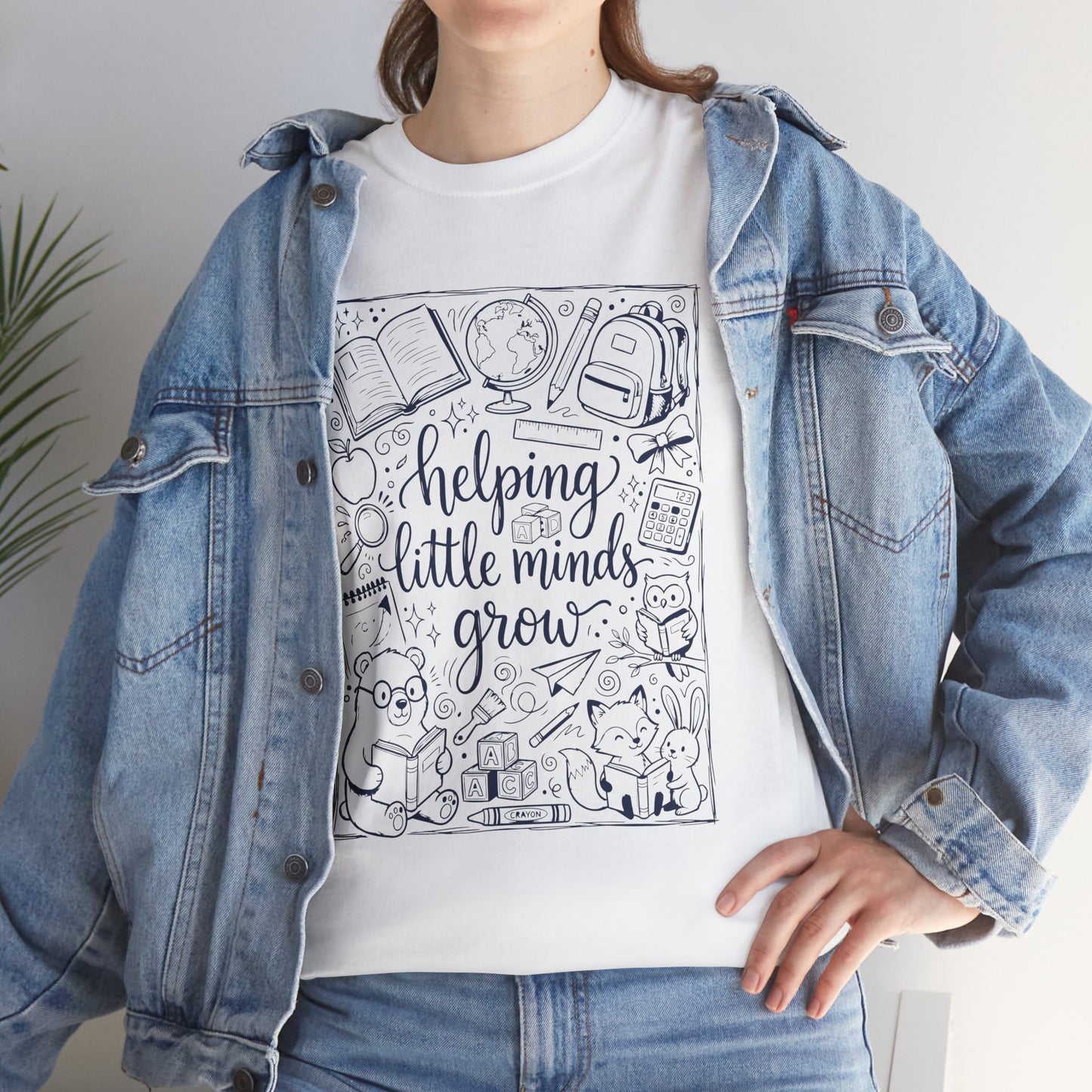 TEEZOCA White T-Shirt with black and white back to school teacher design featuring “helping little minds grow” and school doodles 
