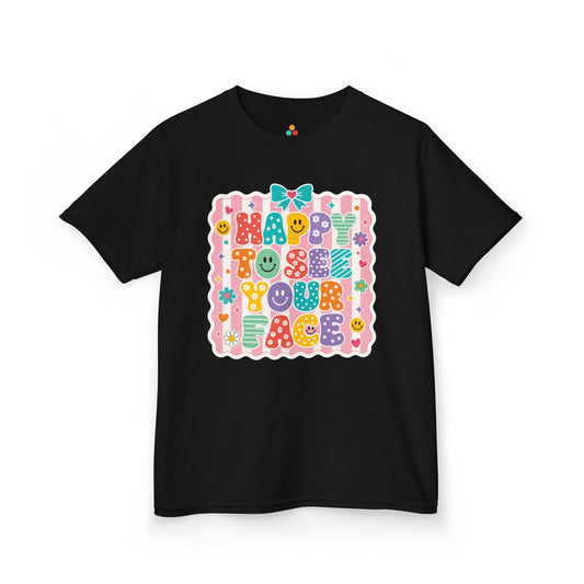 TEEZOCA black Happy to See Your Face kids shirt laid flat, cute coquette lettering with a bow and cheerful faces, a cute back to school tee.

