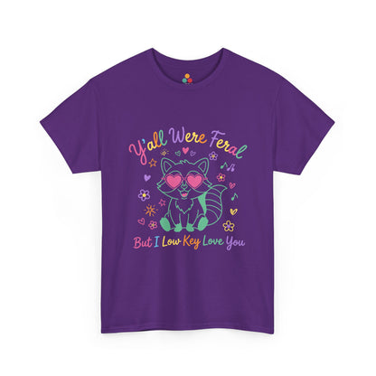 TEEZOCA t-shirt featuring Y'all Were Feral But I Low Key Love You artwork with a colorful raccoon teacher graphic.
