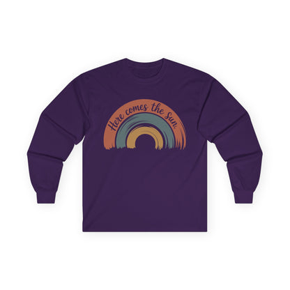 TEEZOCA unisex long-sleeve t-shirt featuring here comes the sun artwork Purple long-sleeve shirt with a rainbow design and text on a white background