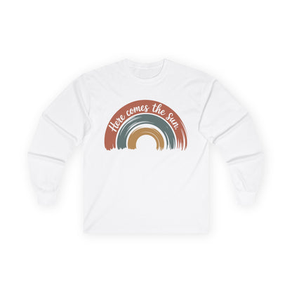 TEEZOCA unisex long-sleeve t-shirt featuring here comes the sun artwork White sweatshirt with rainbow design and 'Here comes the sun' text on a white background