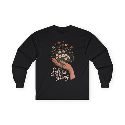 TEEZOCA unisex long-sleeve t-shirt featuring soft but strong hand and flowers Black long-sleeve shirt with floral design and 'Soft but Strong' text on a white background