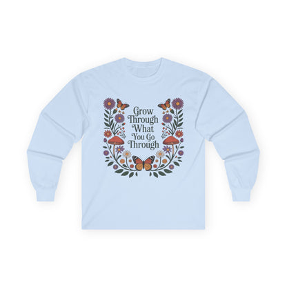 TEEZOCA unisex long-sleeve t-shirt with grow through what you go through botanical frame Light blue sweatshirt with floral design and motivational text on a white background