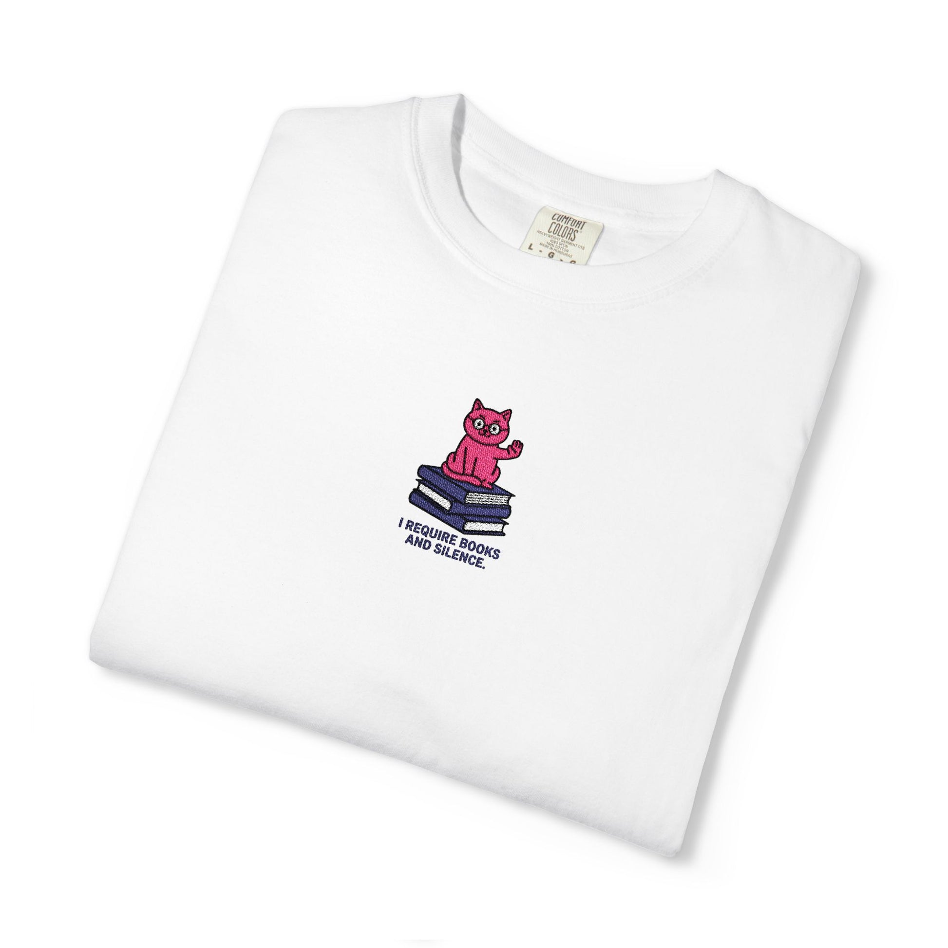 White Comfort Colors®  Island reef  shirt featuring an embroidered pink cat sitting on books with the saying “I Require Books and Silence.”
