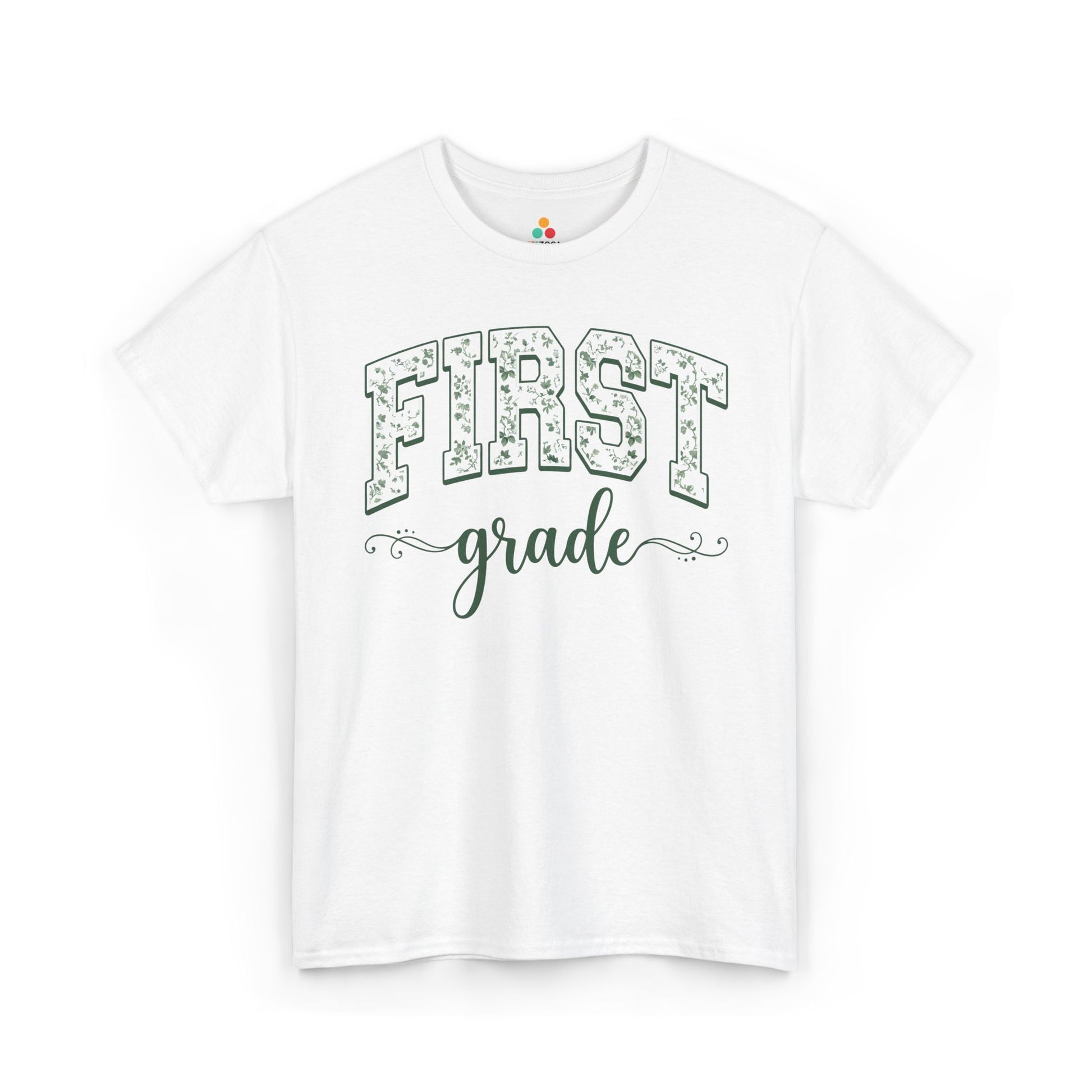 White t-shirt with 'FIRST grade' text on a white background TEEZOCA floral first grade shirt for adults, the kind of teacher tee shoppers find on teezoca.com for the new school year.
