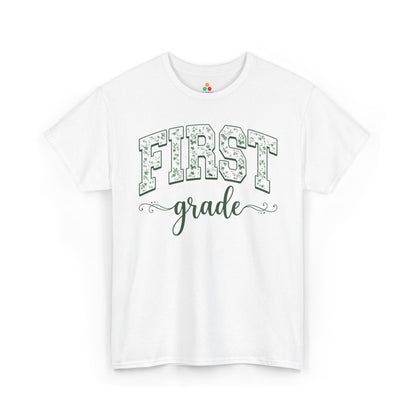 White t-shirt with 'FIRST grade' text on a white background TEEZOCA floral first grade shirt for adults, the kind of teacher tee shoppers find on teezoca.com for the new school year.
