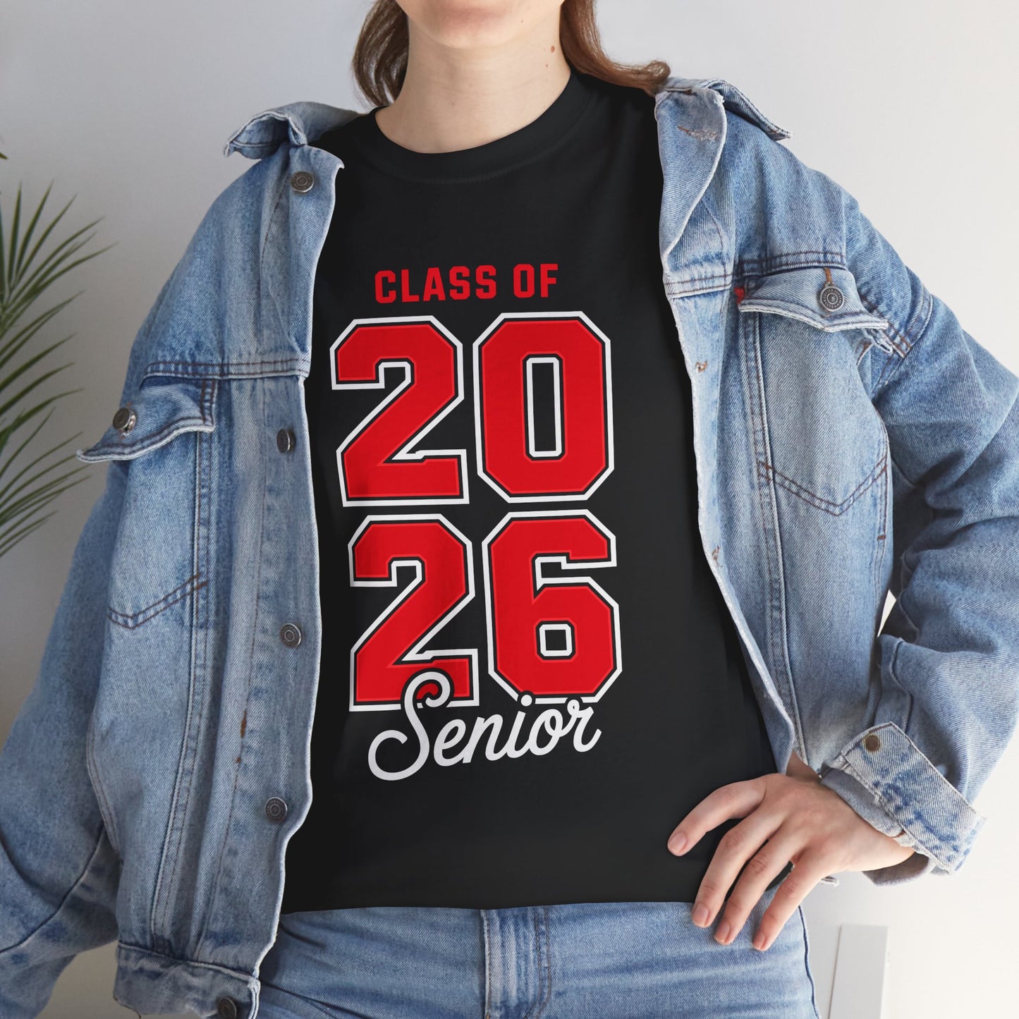 Woman in a denim jacket styling a black TEEZOCA Class of 2026 red numbers senior tee.