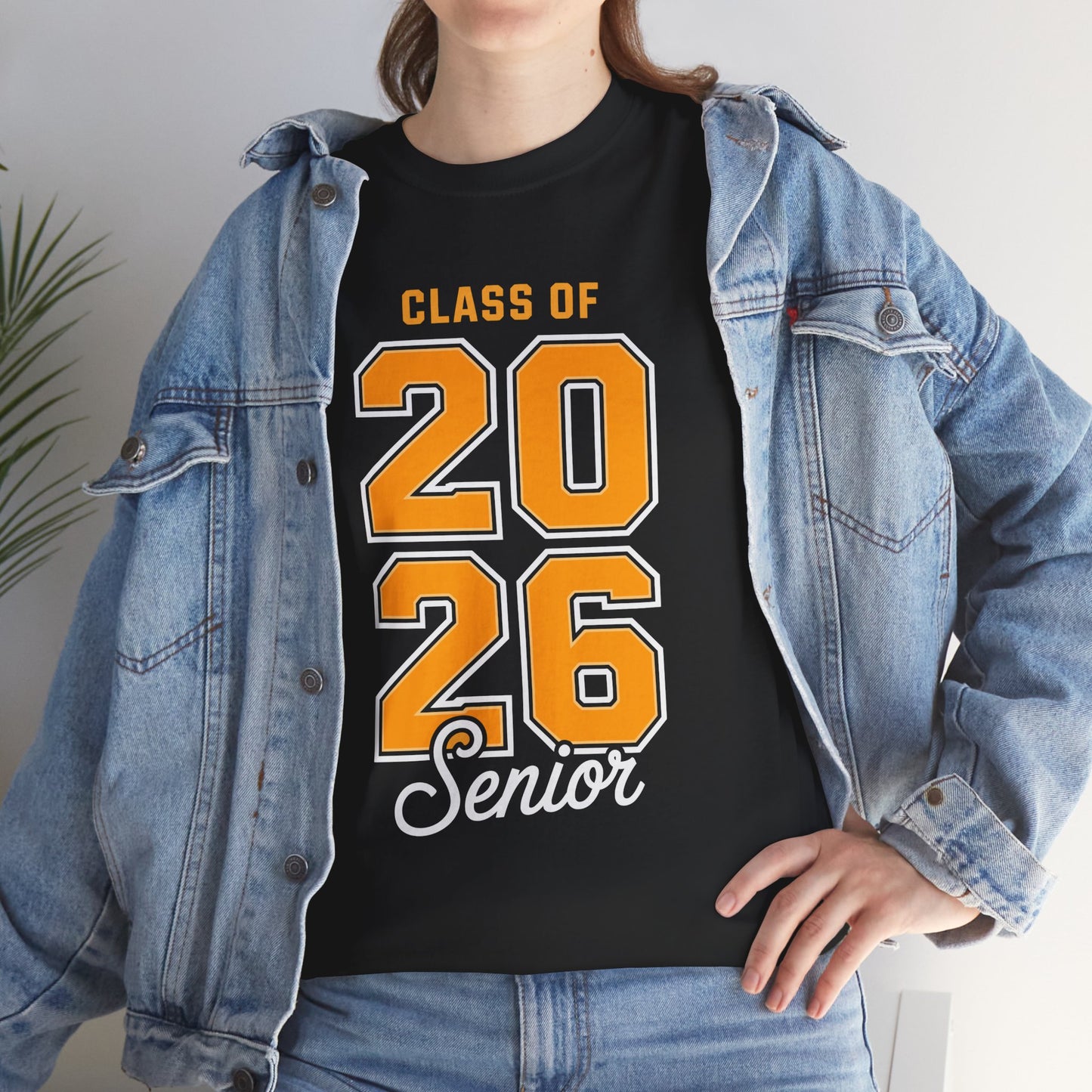 Woman in a denim jacket styling a black TEEZOCA Class of 2026 yellow numbers senior tee.
