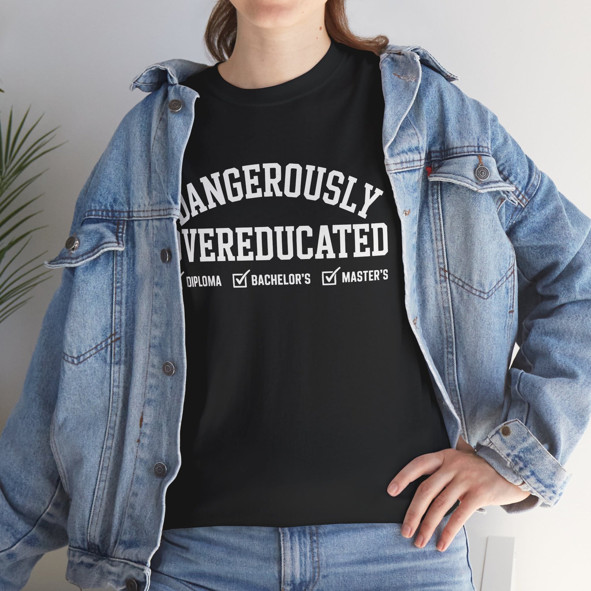 Woman in a denim jacket styling a black TEEZOCA Dangerously Overeducated academic humor tee.