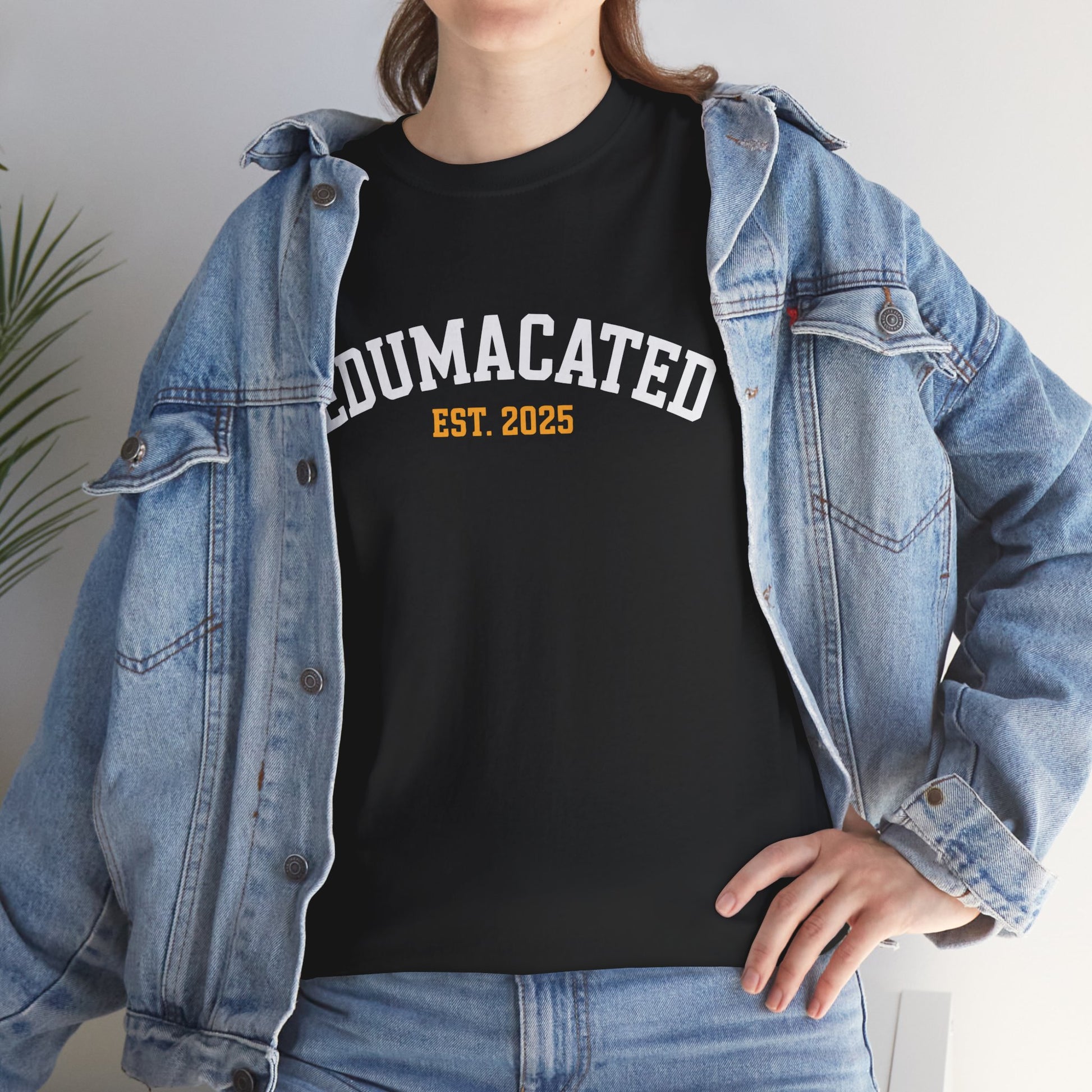 Woman in a denim jacket styling a black TEEZOCA Edumacated Est. 2025 collegiate tee.
