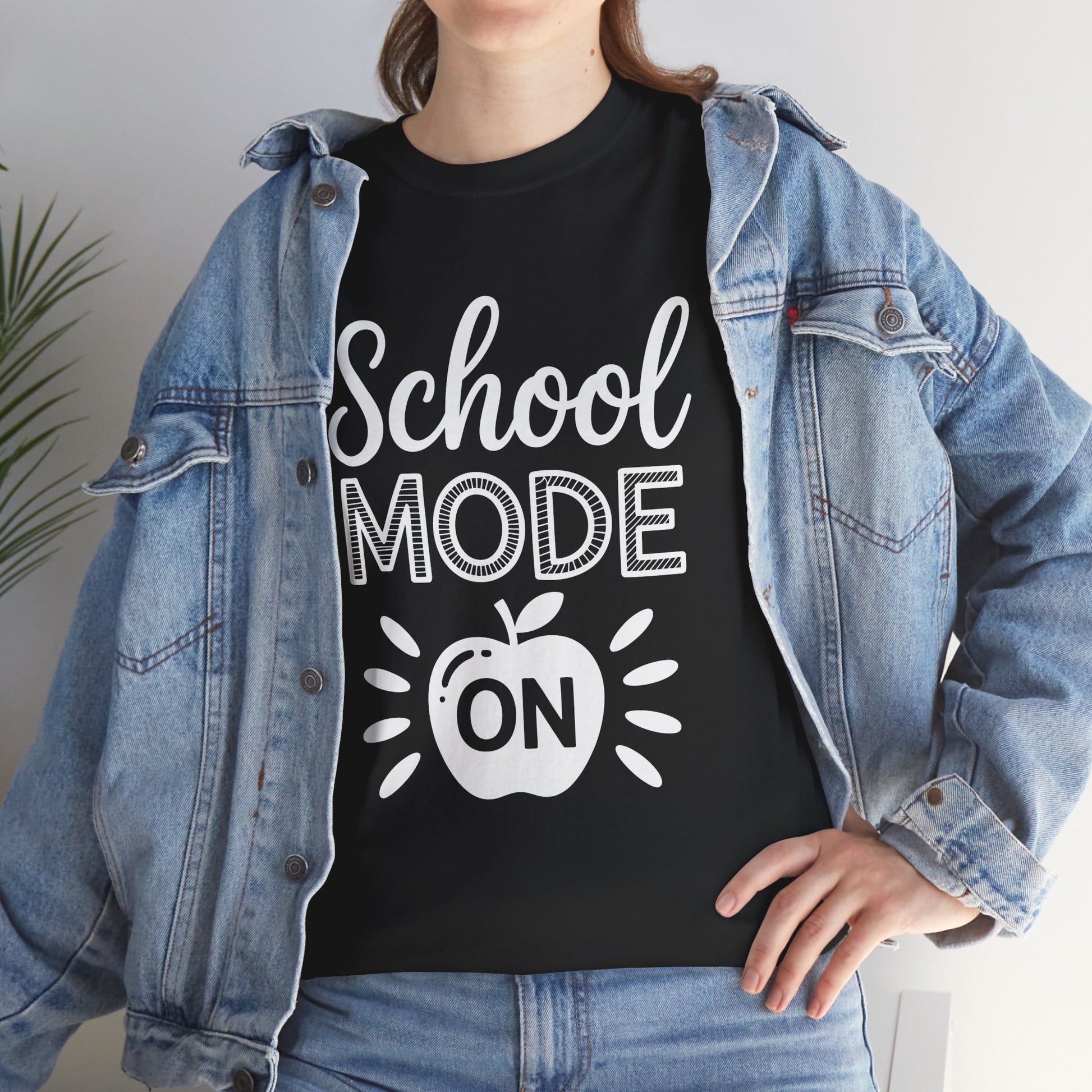 Woman wearing TEEZOCA black “School Mode On” teacher shirt under denim jacket.