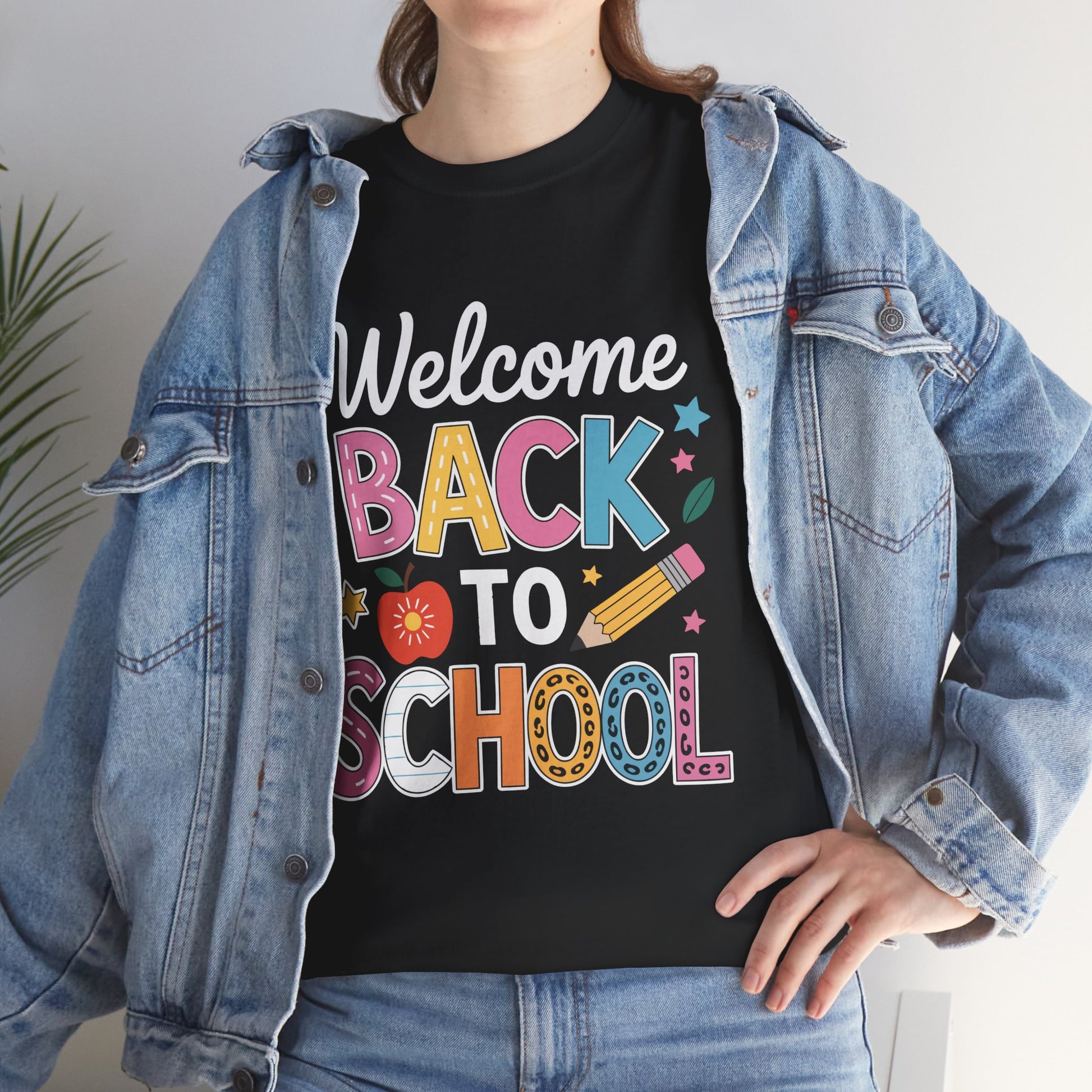Woman wearing TEEZOCA black “Welcome Back To School” tee under denim jacket.